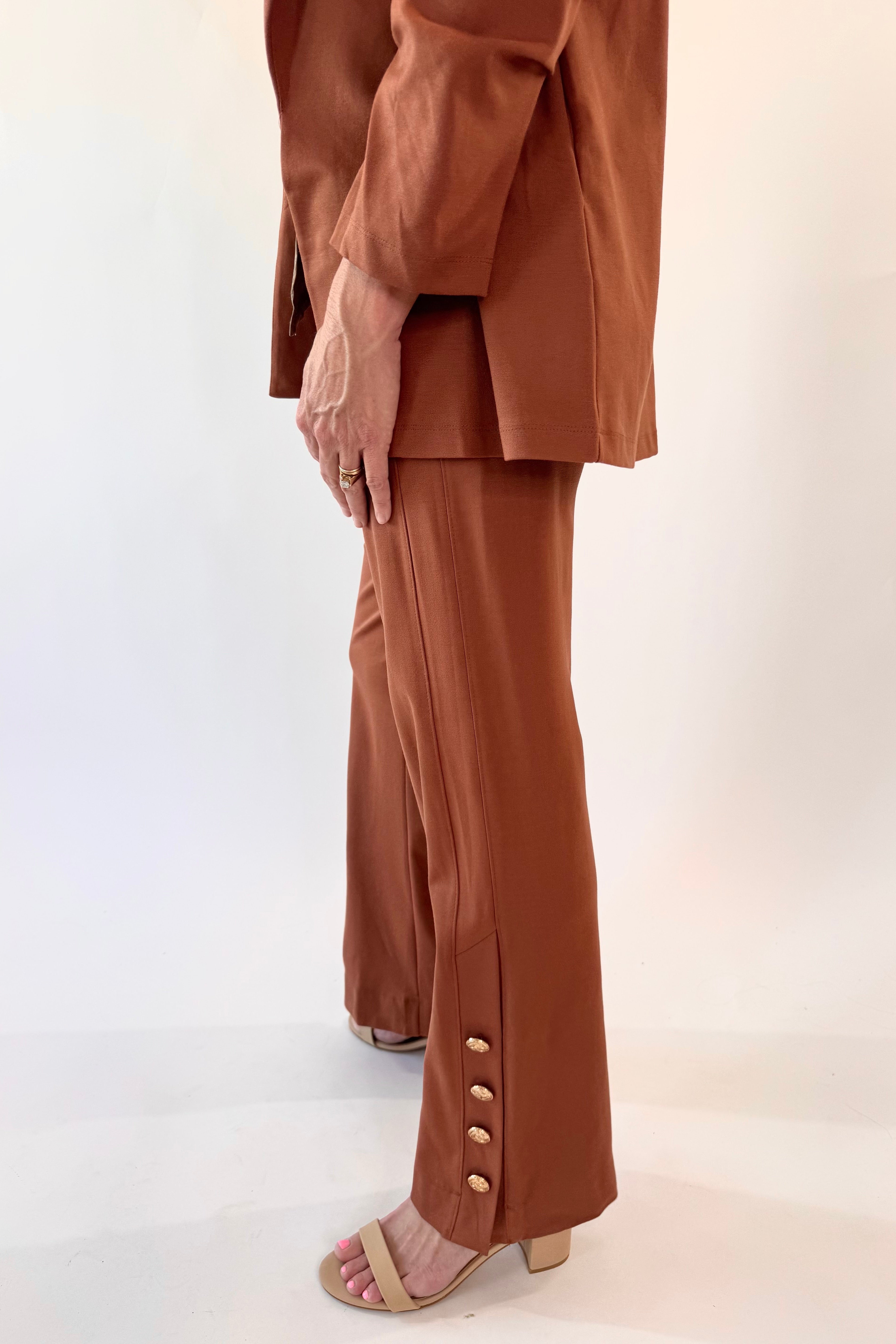 Person wearing a brown suit with wide-leg pants on a white background
