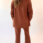 Person wearing a brown outfit against a white background
