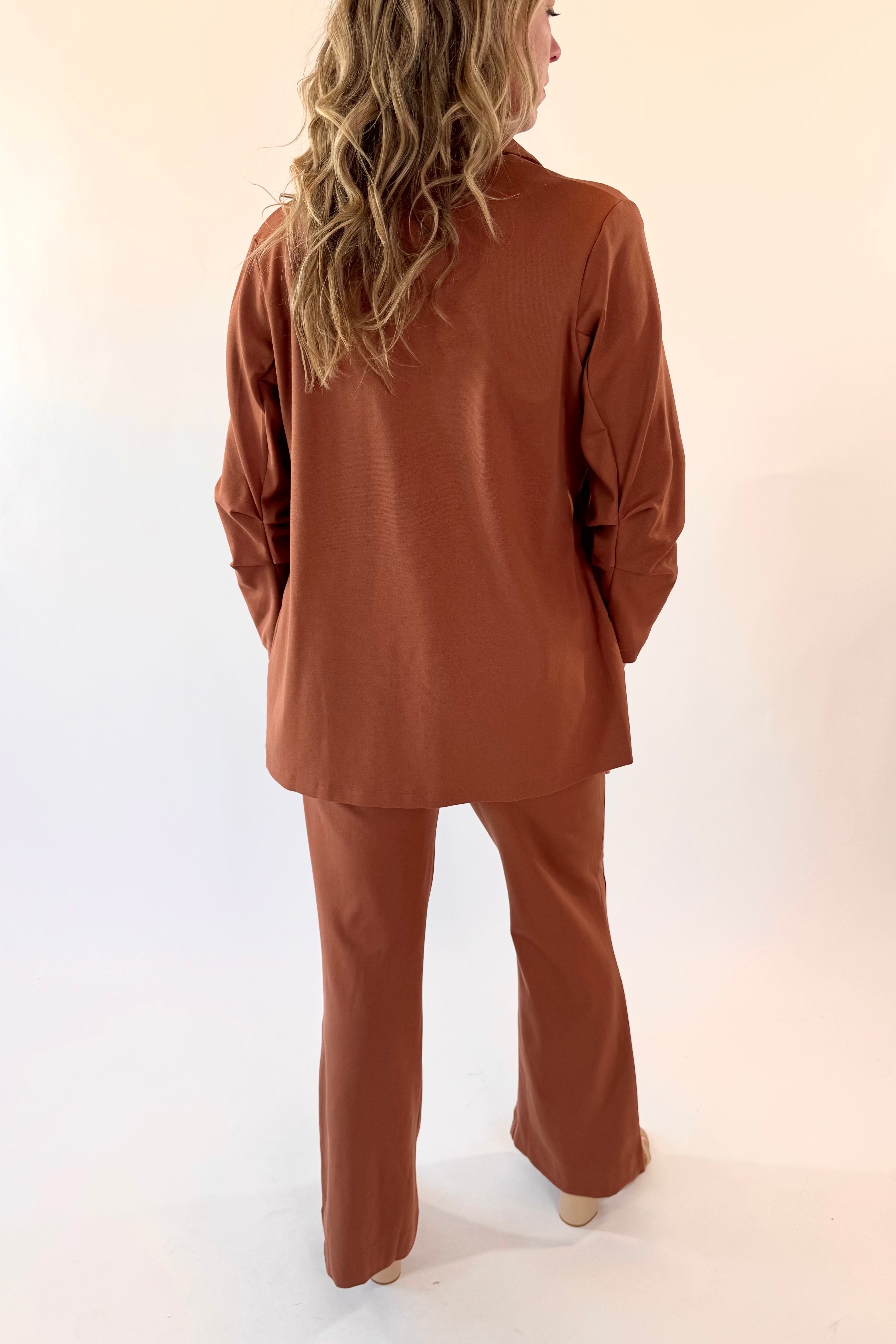 Person wearing a brown outfit against a white background