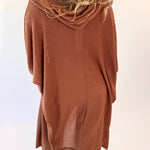 Person wearing a brown hooded garment on a white background