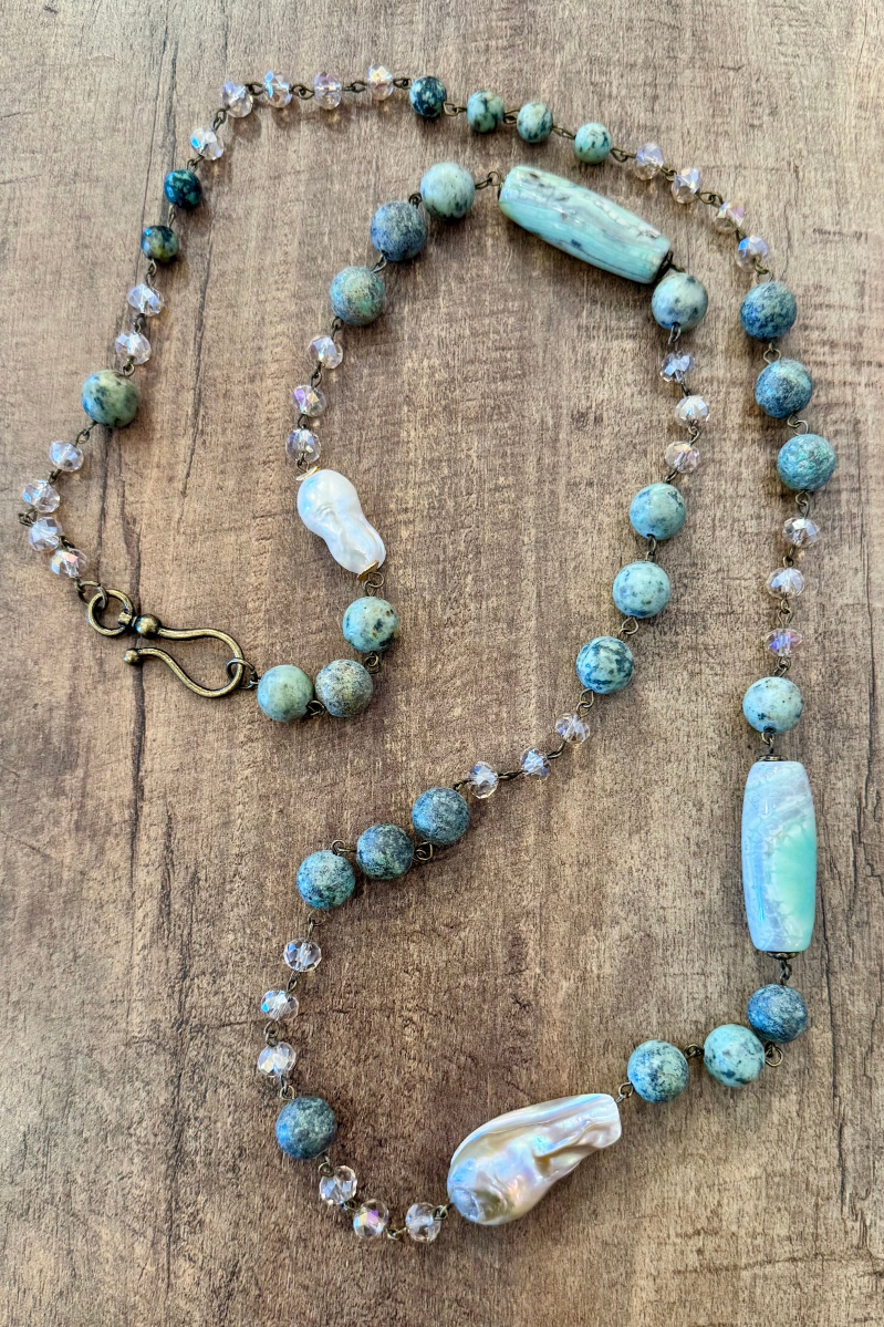 Necklace with turquoise and white beads on a wooden surface