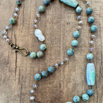 Necklace with turquoise and white beads on a wooden surface