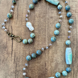 Necklace with turquoise and white beads on a wooden surface