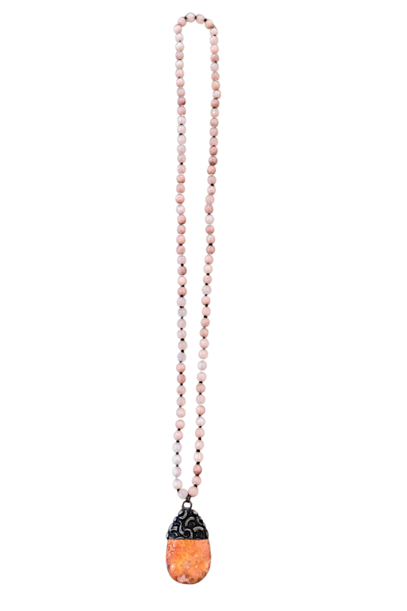 Necklace with pink beads and a colorful pendant on a white background