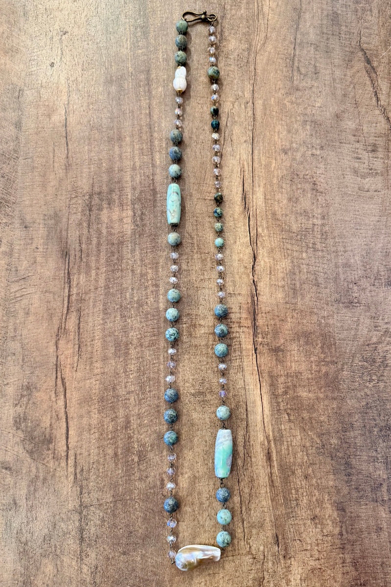 Necklace with turquoise and white beads on a wooden surface