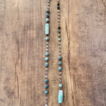 Necklace with turquoise and white beads on a wooden surface