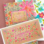 Floral-themed greeting cards on a pink background