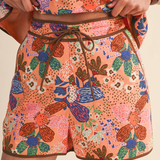 Colorful floral-patterned shorts with a brown drawstring on a neutral background wearing Wildflower Market Shorts