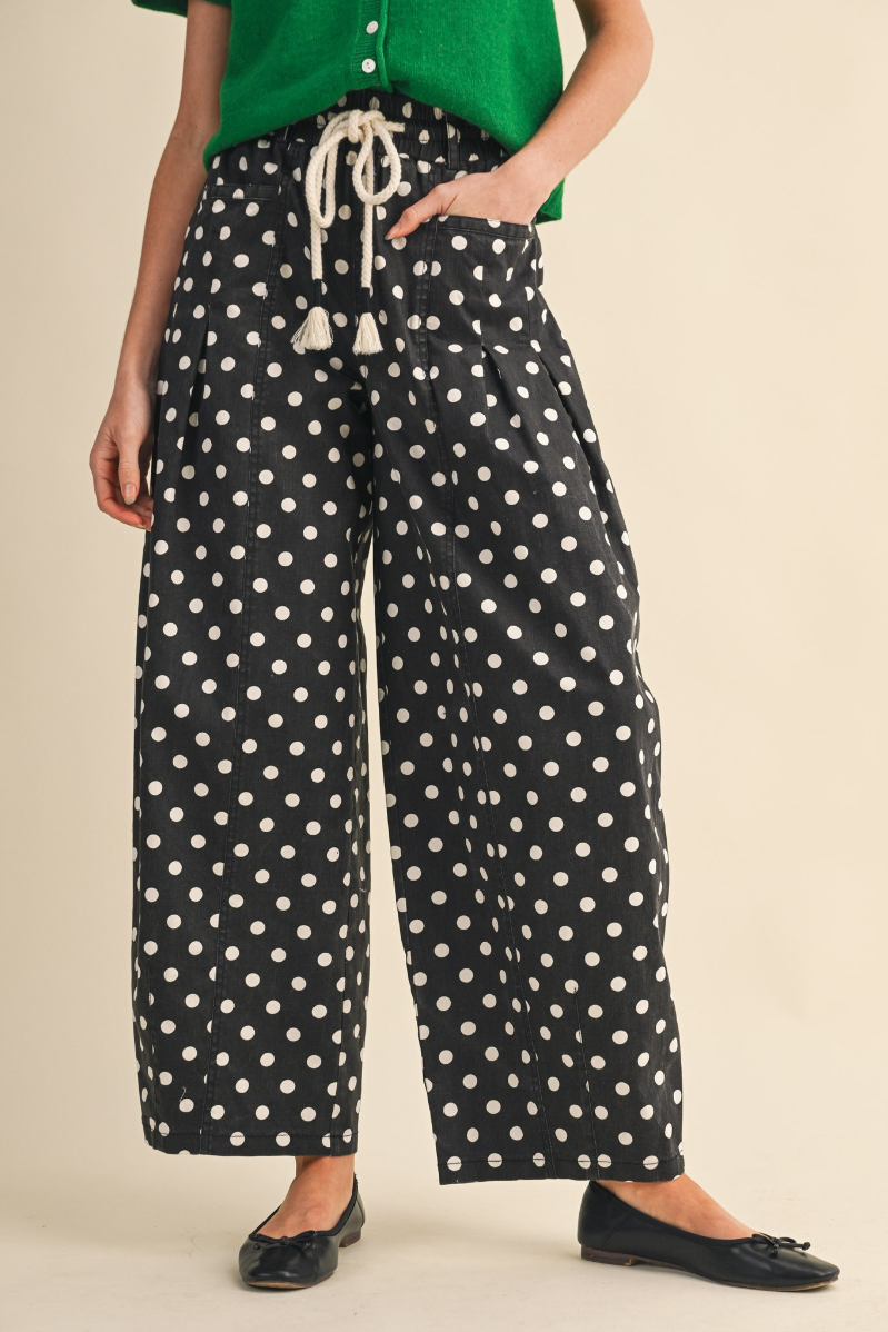 Woman standing in Black and White Polka Dot Pleated Barrel Pants.