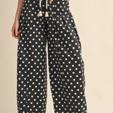 Woman standing in Black and White Polka Dot Pleated Barrel Pants.