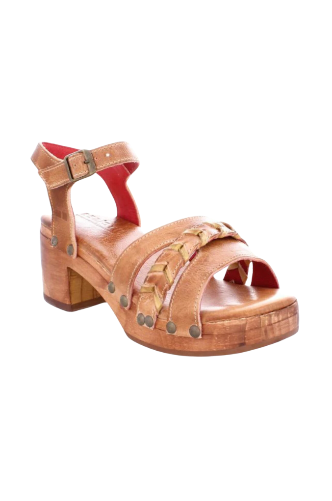 A tan-colored leather sandal with braided leather accents, metal studs, red leather lining, and a manageable heel height, displayed against a white background.