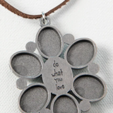 Silver pendant with circular cutouts and 'do what you love' engraving on a white background