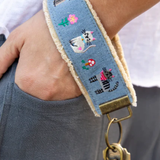 Wristlet with cat design and gold clasp worn on wrist