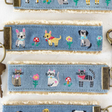 Set of denim keychains with embroidered animal designs on a white background