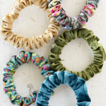 Five colorful scrunchies on a white background