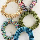 Five colorful scrunchies on a white background