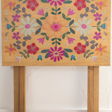 Wooden table with floral design on a white background