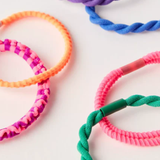 Colorful braided hair ties on a white background