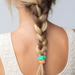 Braided hair with colorful beads on a plain background