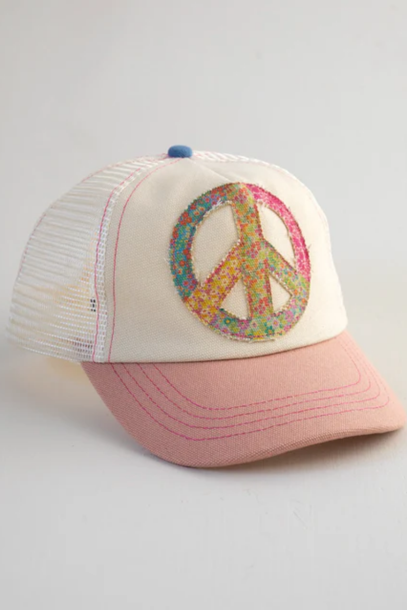 Cap with peace symbol design on a light gray background