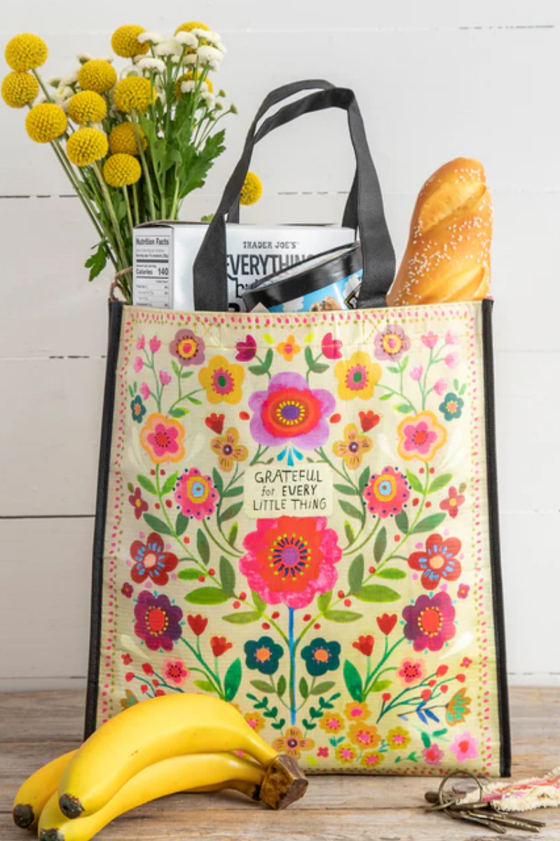 Floral-patterned tote bag with groceries on a wooden surface