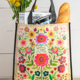 Floral-patterned tote bag with groceries on a wooden surface