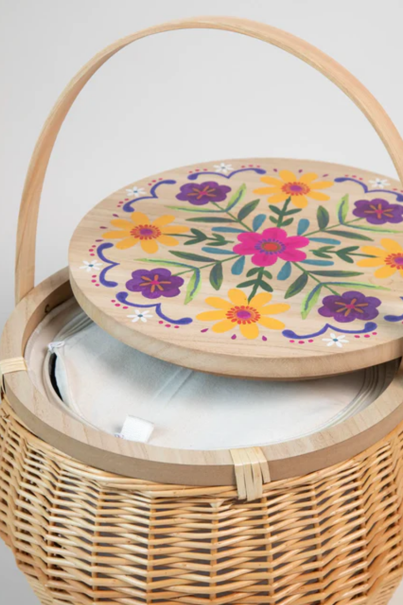 Wicker basket with a floral lid on a light gray background