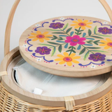 Wicker basket with a floral lid on a light gray background