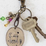 Keychain with cat charm and keys on a white background