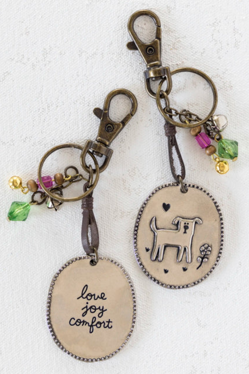 Two keychains with oval tags and metal clasps on a white background