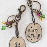 Two keychains with oval tags and metal clasps on a white background