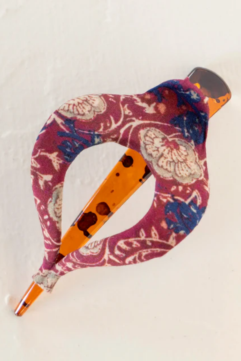 Decorative claw clip with floral pattern and orange accents on a white background