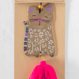 Cat-shaped air freshener with floral design on a cardboard backing