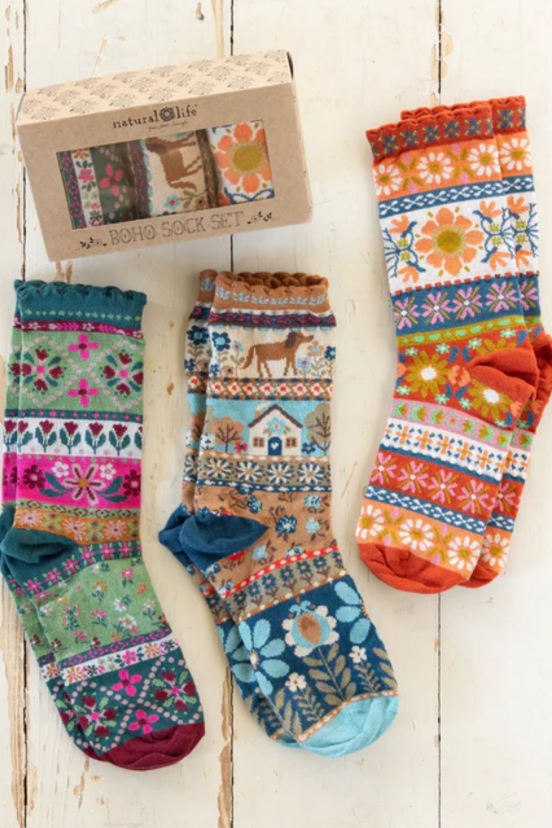 Set of colorful patterned socks with a 'natural life' box on a wooden surface