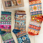 Set of colorful patterned socks with a 'natural life' box on a wooden surface