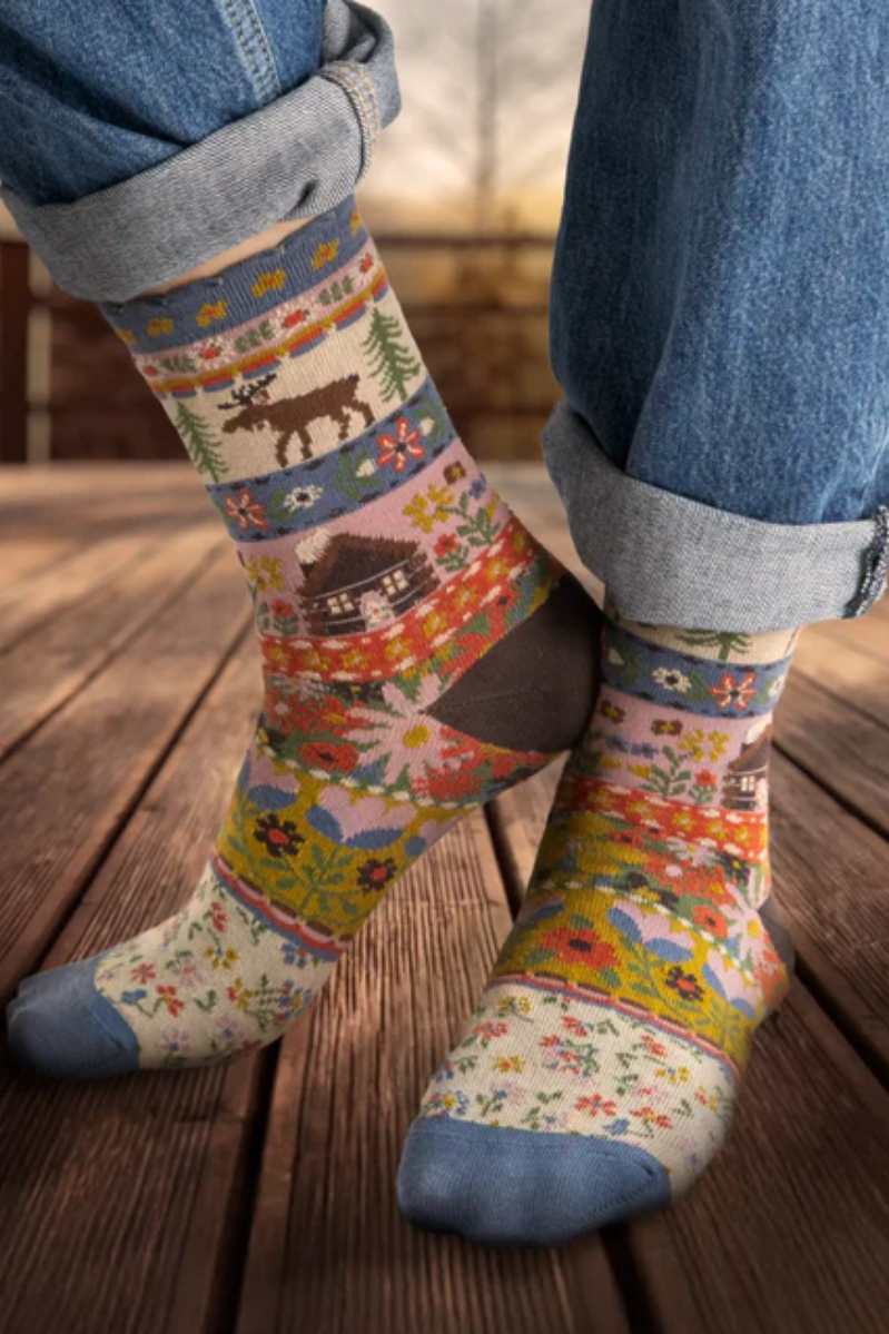 Colorful patterned socks worn on a wooden floor