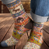 Colorful patterned socks worn on a wooden floor