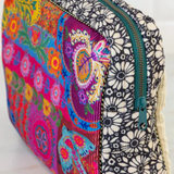 Colorful floral and geometric patterned pouch with a zipper on a white background