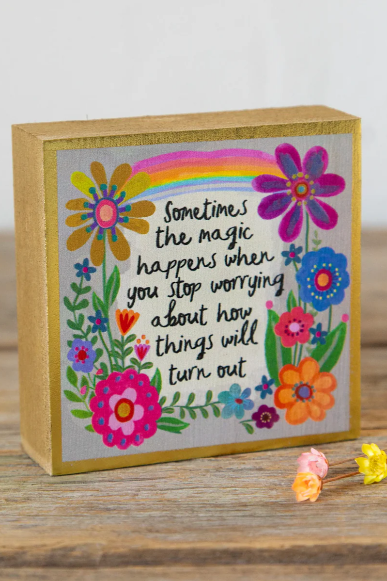 Decorative box with colorful flowers and a rainbow, featuring a motivational quote.