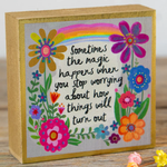 Decorative box with colorful flowers and a rainbow, featuring a motivational quote.