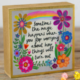 Decorative box with colorful flowers and a rainbow, featuring a motivational quote.