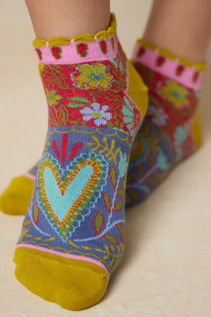 Colorful socks with floral and heart patterns on a beige background