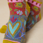 Colorful socks with floral and heart patterns on a beige background