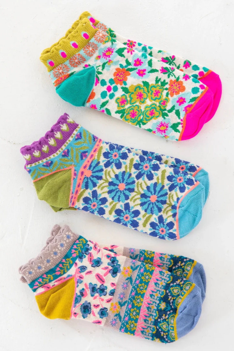Set of colorful floral-patterned socks on a white background