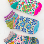 Set of colorful floral-patterned socks on a white background