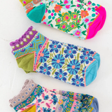 Set of colorful floral-patterned socks on a white background