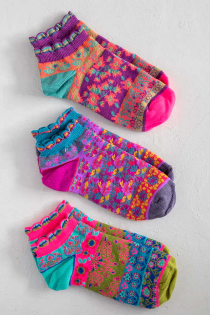 Three pairs of colorful patterned socks on a light gray background