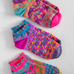 Three pairs of colorful patterned socks on a light gray background