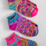 Three pairs of colorful patterned socks on a light gray background