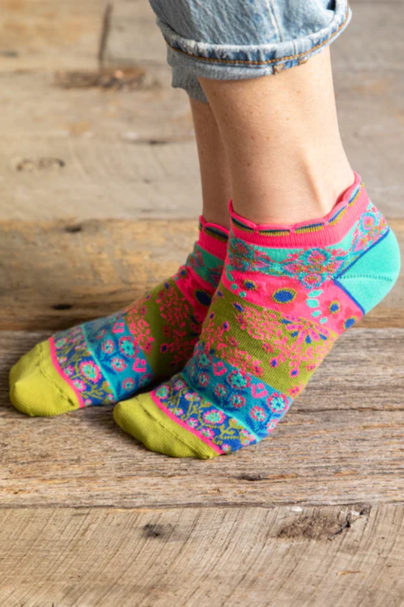 Colorful patterned socks worn on a wooden floor